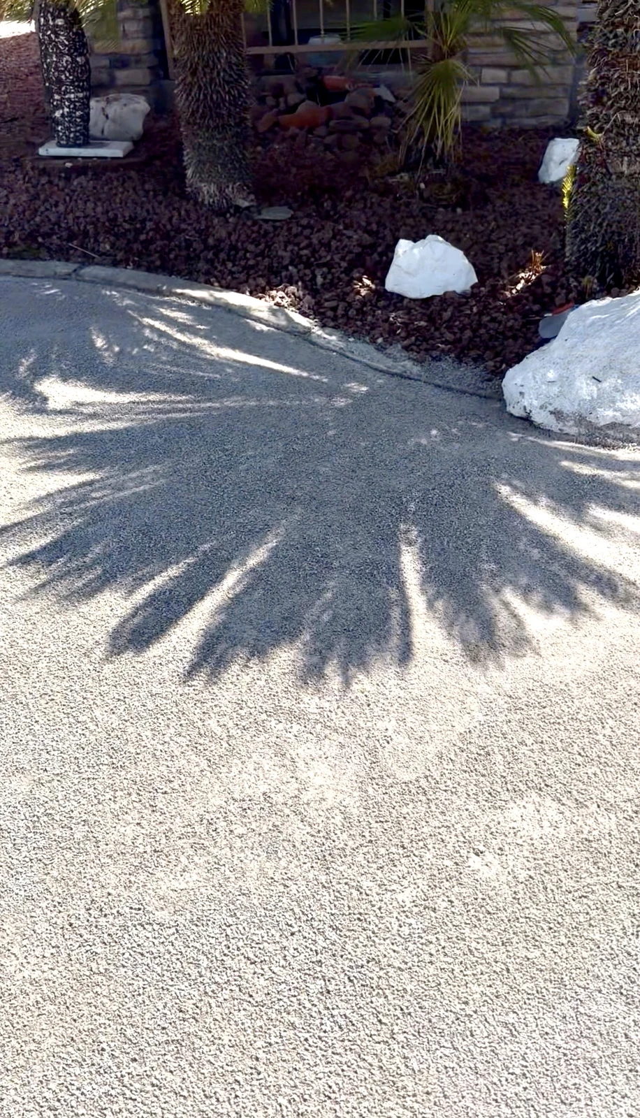 Bare gravel driveway edge before artificial turf installation